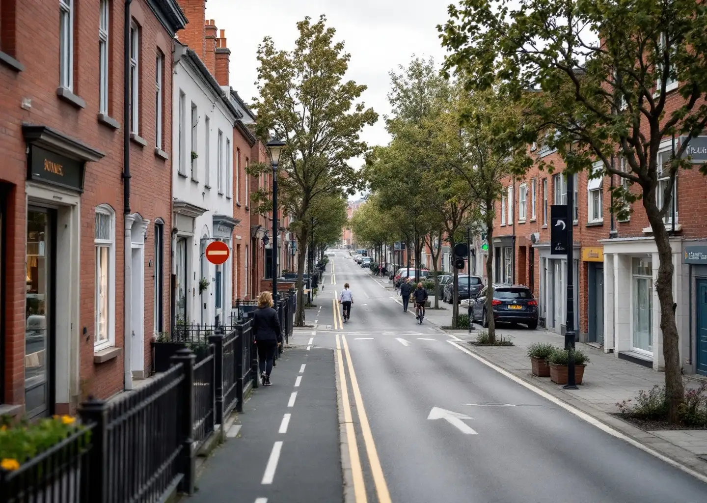 Avenue commerçante se prolongeant en boulevard urbain, sans rupture visible entre les deux communes